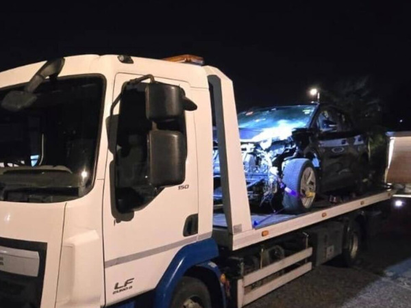 A recovery driver attending to a damaged vehicle after an incident