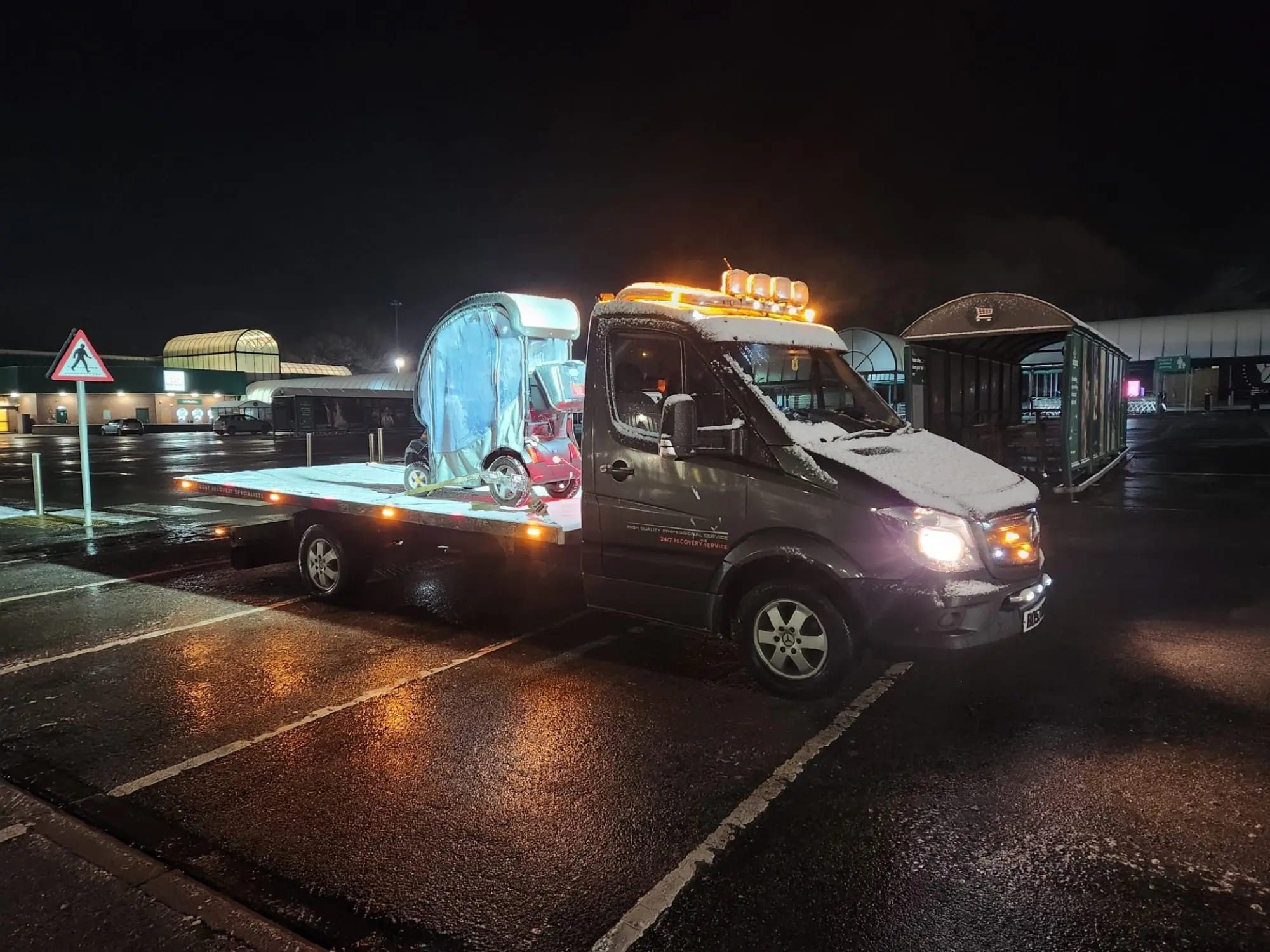 A vehicle secured on a flatbed being transported in the UK